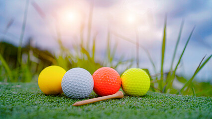 Naklejka premium Golf ball on green grass in the evening golf course with sunshine background.