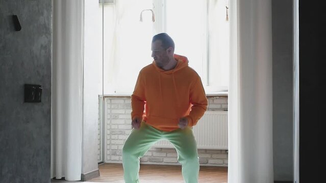 A very positive and funny dancer in the hotel. A very happy dancing man. Listen to music and dance in the apartment