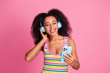 Portrait of good mood adorable girl wear colorful top touch headphones listen pop music in...