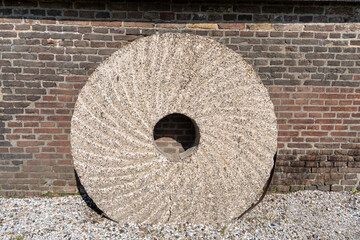A textured mill stone, used for grinding flour from wheat in the traditional rural way. © Hazel