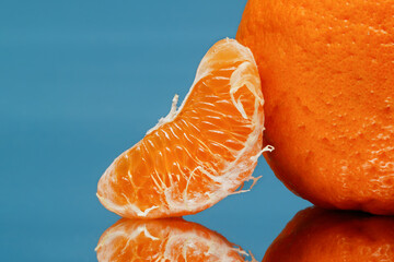 Slice of tangerine on a blue background. Selective focus