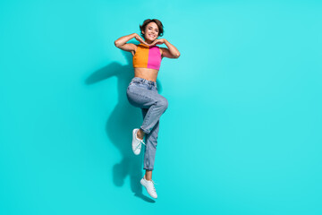 Full length photo of dreamy cute lady dressed colorful top jumping high smiling empty space...