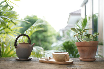 wooden Tea cup and earthenware teapot at the balcony and notebooks side view