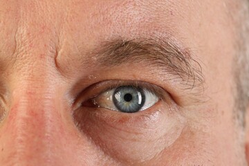 Fototapeta premium Macro photo of man with beautiful blue eyes