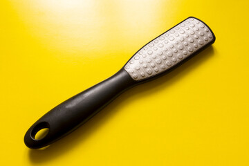 Foot brush close-up on a yellow background.
