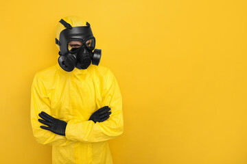 Worker in gas mask with crossed arms on yellow background. Space for text