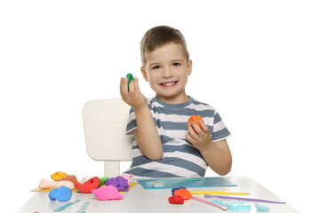 Smiling boy with play dough handiwork at table on white background