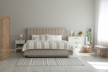 Stylish interior of contemporary bedroom with comfortable bed