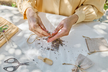 Woman making lavender sachet, small bag to scent clothes to put it in wardrobe. Zero waste DIY gift. Homemade aromatherapy.