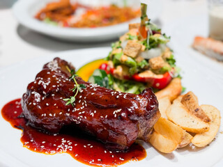 Barbeque pork spare ribs with vegetables and chips.