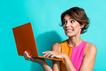 Photo of shocked guilty lady dressed colorful top having working problems modern gadget isolated...