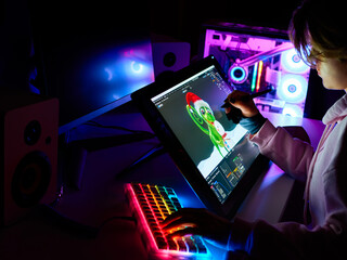 Female 3D designer is working on a project on a graphic tablet with a screen. Digital designer creates a model for a video game or cartoon