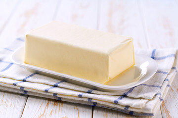 piece of butter on a light wooden table, selective focus.