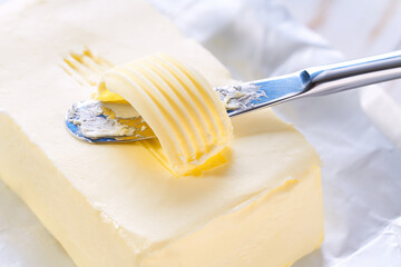 knife slicing through butter close up.