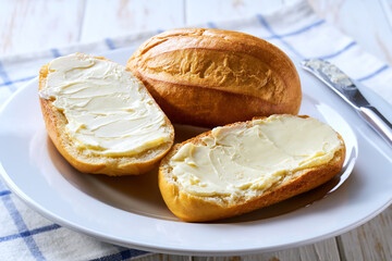 spreading butter on french bread or traditional Brazilian bread.