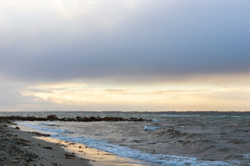 Sea scenery with rock pier an cloudy sky.