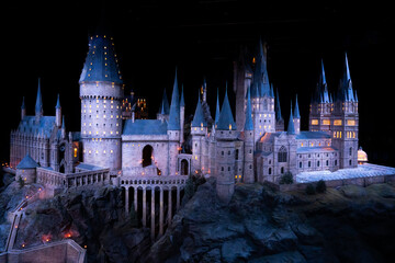 Naklejka premium JAPAN - Nov 13, 2023: Stunning night view of Hogwarts Castle, beautifully illuminated showcasing iconic towers and intricate architecture at Warner Bros. Studio Tour Tokyo, The Making of Harry Potter