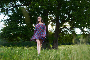 Gorgeous hispanic young woman on a meadow with oak forest