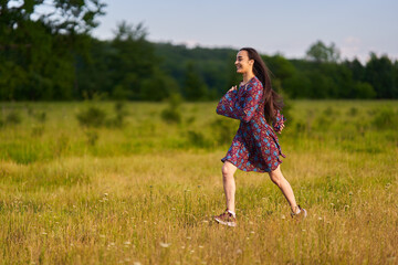 Gorgeous hispanic young woman on a meadow with oak forest