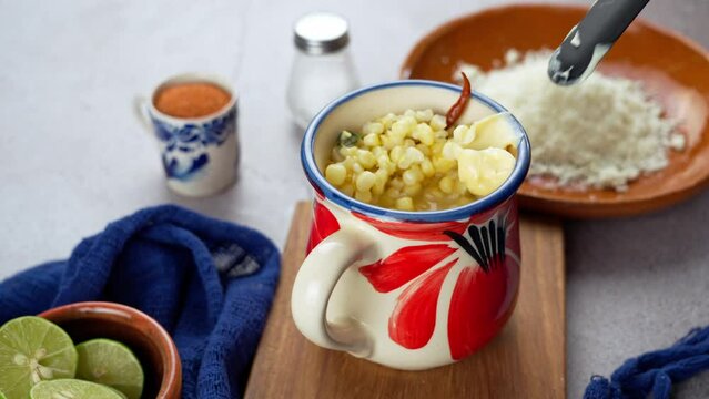Putting mayonnaise on the Esquites, mexican food