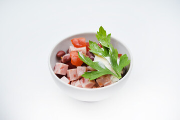 Vegetable salad with meat and sauce in a white salad bowl. A small snack.