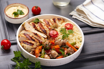 Lunch bowl with grilled chicken fillet meat, couscous, carrot, green beans and mushrooms. 