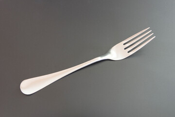 Stainless steel fork on a black background.