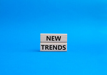 New Trends symbol. Wooden blocks with words New Trends. Beautiful blue background. Business and New Trends concept. Copy space.