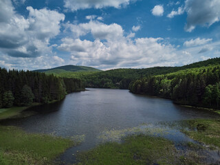 Fototapeta premium Lake Trei Ape Three Waters photographed from a drone flight. The blue sky with clouds and green forests.