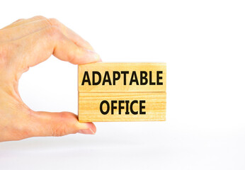 Adaptable office symbol. Concept words Adaptable office on beautiful wooden block. Beautiful white paper background. Businessman hand. Business Adaptable office concept. Copy space.