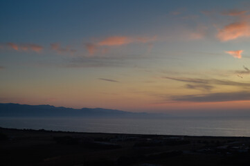 Paddle boarders on a calm sea at sunset
