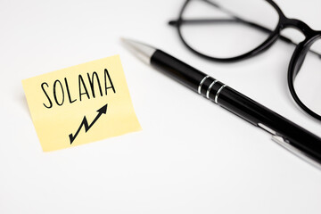 A yellow piece of paper on a white background with a handwritten inscription 