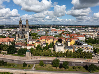 Naklejka premium Telephoto photo of Magdeburg. Cloudy sky over the city. State capital of Saxony-Anhalt. City wall in front of the cathedral square. City center shot in summer. Travel destination in Germany.