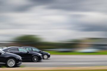 Fast moving cars on highway with motion blur background. Concept of speeding, illegal car racing, dangerous driving.