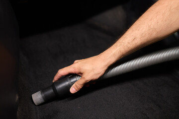 Fototapeta premium Professional car interior vacuuming with handheld vacuum for thorough cleaning and maintenance