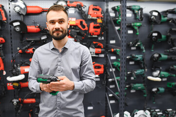 a buyer in a hardware store walks between with a power tool