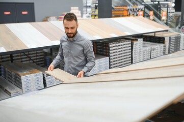 man choosing laminate samples in hardware store