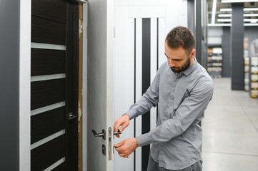 Fototapeta premium A man chooses doors in a hardware store for his apartment