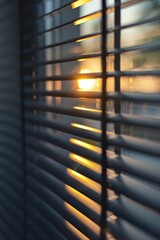 A warm sunset scene peeking through blinds in a window, ideal for interior design or home decor images