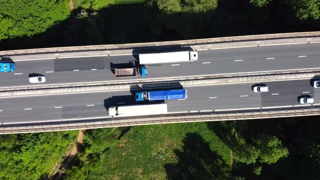 Aerial view of car driving along the dual carriageway road through green meadows landscape on sunny day near Wentbridge West Yorkshire UK. Drone chasing a car.