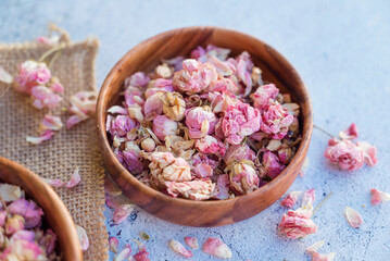 Flower tea rose buds in wooden bowl