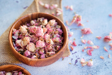 Flower tea rose buds in wooden bowl