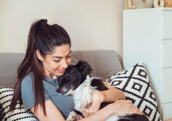 Woman Hugging her Adopted Black Dog at Home