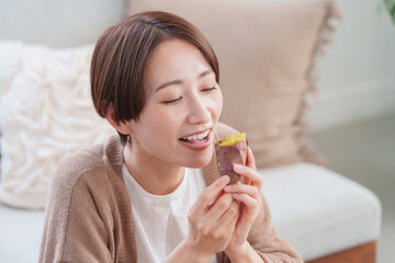 焼き芋を食べる女性（秋・食事・さつまいも）