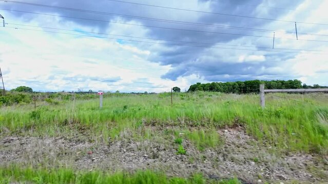 Point of view, right side car view. Passenger window side driving view of stormy clouds. POV on 401 highway driving storm on the horizon. Roads of Canada. Car driving on the road.