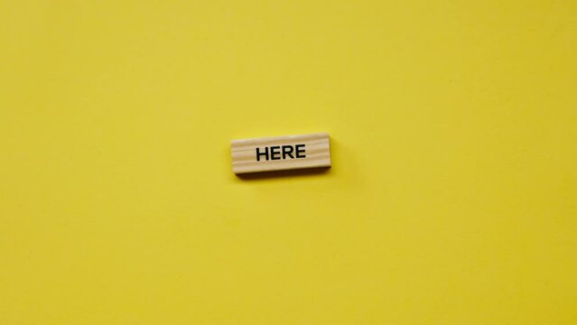 a Yellow warm background without shadows the male hand laid wooden cubes with colored words laid out the stop here