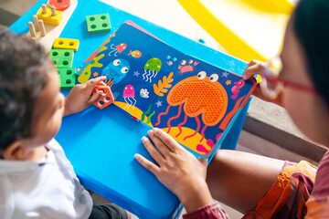 Image of an open children's book showing a colorful octopus and ocean animals, where a mother teaches her young child about these animals