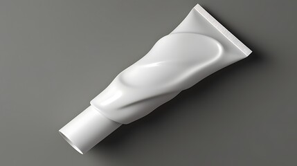 White plastic tube of cream or gel. The tube is squeezed and deformed. Gray background.