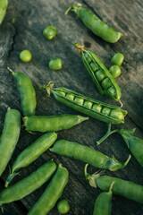 Green Peas. Green background. Green pea top view copy space. Fresh organic green peas. Vegetable harvesting. Beautiful close up of fresh peas and pea pods. Healthy vegetarian food
