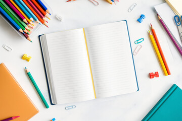 Colorful stationery layout featuring an open workbook and various pencils on a desk. Perfect for visual content related to organized study areas, vibrant office setups, and student productivity